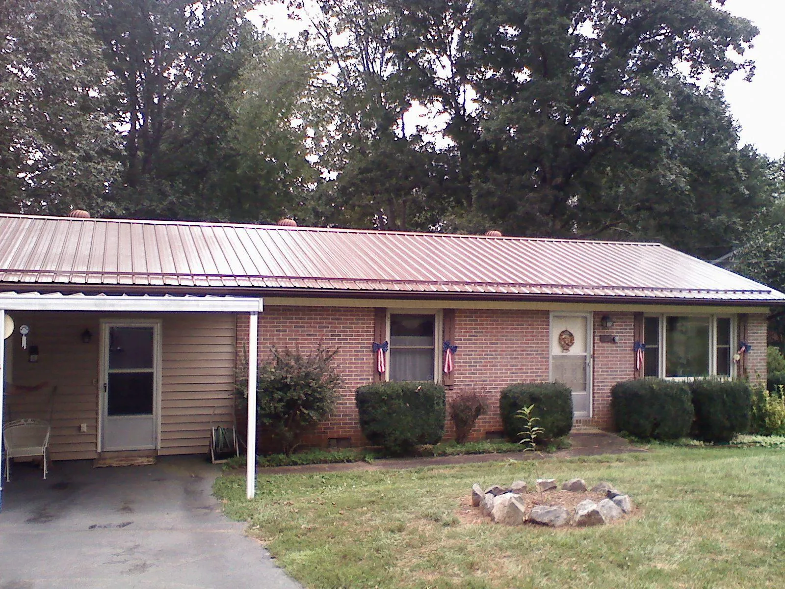 Bronze metal roof and carport on a brick ranch home — Roof Repair work by our crew in Pillsbury
